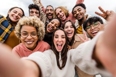 Multiracial friends taking big group selfie shot smiling at camera – Laughing young people standing outdoor and having fun – Cheerful students portrait outside school – Human resources concept