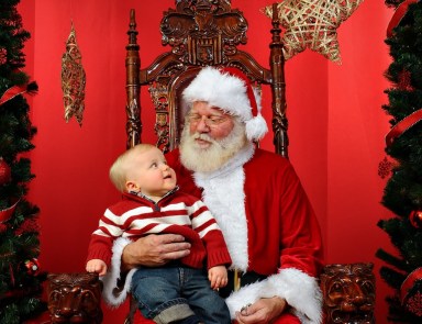 Baby,Boy,Sitting,On,Santa’s,Lap,At,Christmas,Time.