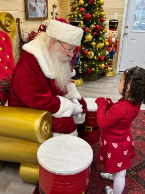 Santa Greets Child at Photo Session at Cross County Center