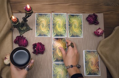 Tarot cards on wooden desk table of fortune teller. Tarot reading.