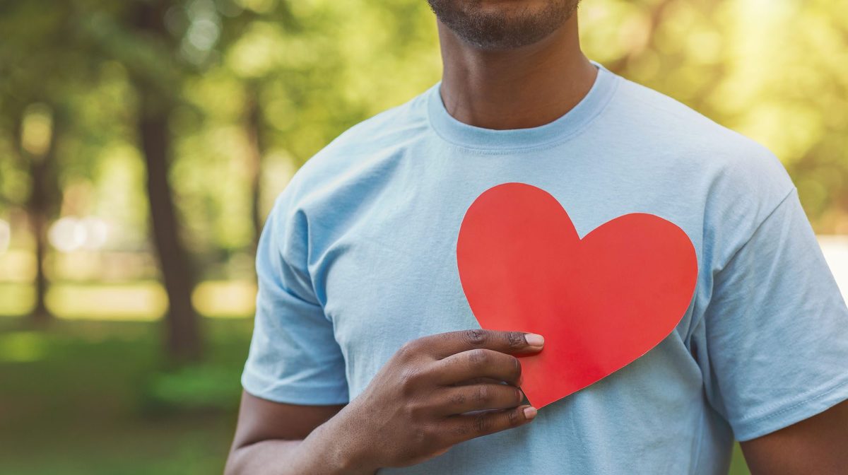 Black man holding red heart on his chest