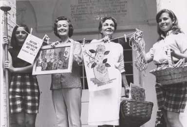 Women Posing at Outside Clothesline Art Sale at Guild Hall